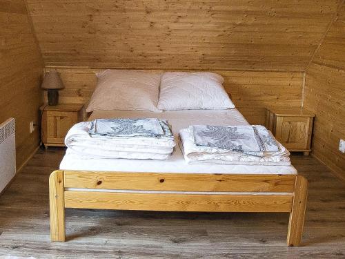 a bed in a wooden cabin with two pillows on it at Sea view holiday home in Mielno with balcony in Mielno