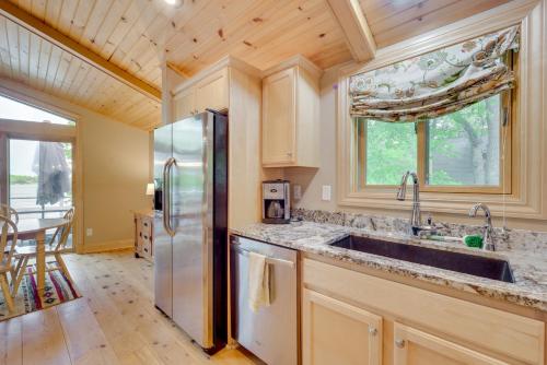 a kitchen with a sink and a refrigerator at Wisconsin Vacation Rental with Fire Pit on Long Lake 