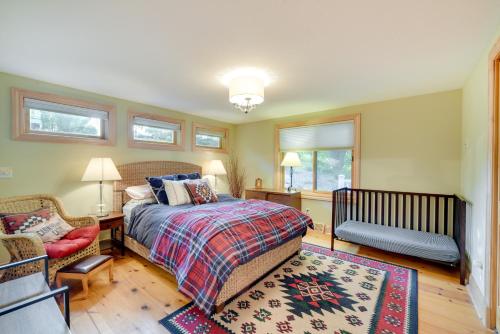 een slaapkamer met een bed, een stoel en ramen bij Wisconsin Vacation Rental with Fire Pit on Long Lake 