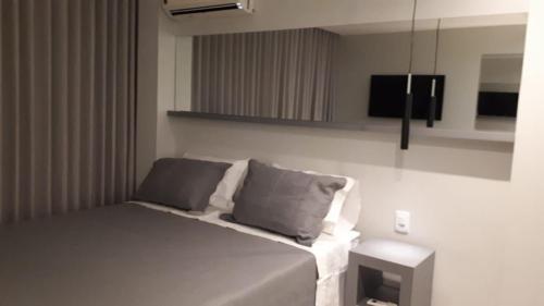 um quarto com uma cama com duas almofadas e uma televisão em Flats Asa Norte CLN 110 by CentoEdez em Brasília