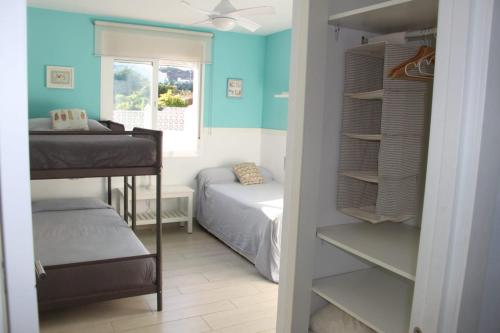 a bedroom with a bed and bunk beds in a room at ATICO con vistas al mar a 100 metros de la playa in Torre de Benagalbón