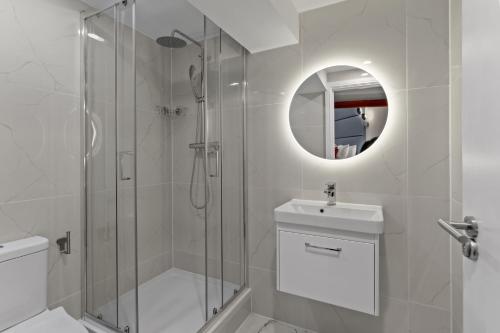 uma casa de banho com um chuveiro, um WC e um lavatório. em Modern Studio Flat em Londres
