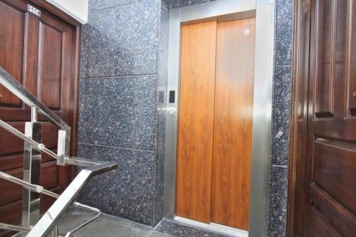 uma casa de banho com uma escada e uma porta de madeira em Hotel Royal Residence HSR Layout em Bangalore