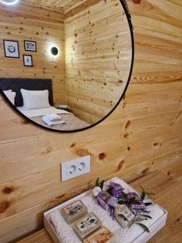 a room with a bed in a wooden cabin with a mirror at OLEA COTTAGE in Ulcinj