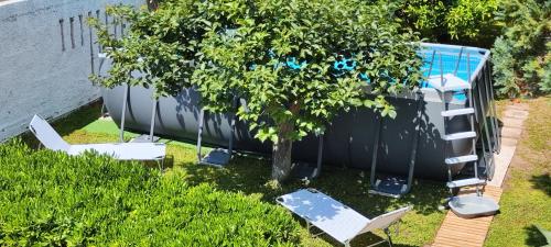 a tree with chairs and a ladder next to a boat at Voscenza Benerica in Vittoria