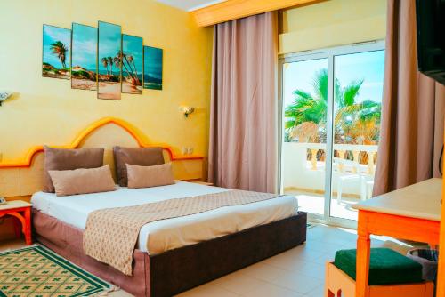 um quarto de hotel com uma cama e uma varanda em Djerba Castille em Aghīr