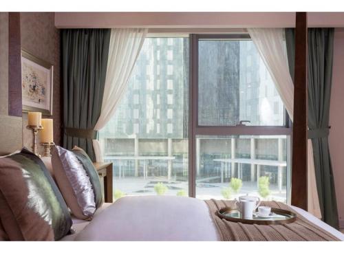 a bedroom with a bed and a large window at Nasma Luxury Stays - Central Park Tower in Dubai