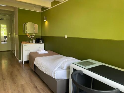 a bedroom with a bed and a desk with a mirror at Hotel Prinsenhof Amsterdam in Amsterdam