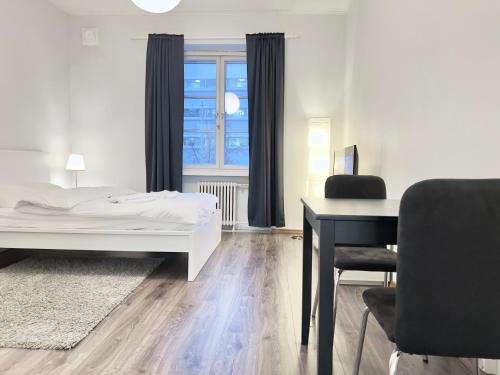 赫爾辛基的住宿－Beautiful Central Apartment Helsinki，一间卧室配有一张床、一张桌子和一把椅子