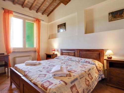een slaapkamer met een bed en een raam bij Comfortable Mansion in Siena with Swimming Pool in Siena