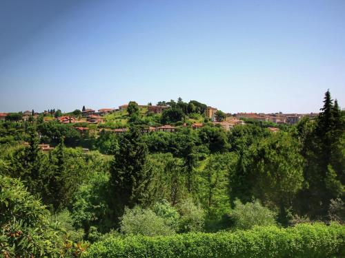 een dorp bovenop een heuvel met bomen bij Comfortable Mansion in Siena with Swimming Pool in Siena