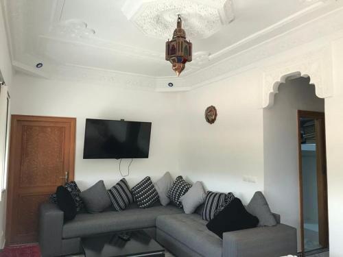 sala de estar con sofá y TV de pantalla plana en Les portes de l'atlas, en Fez