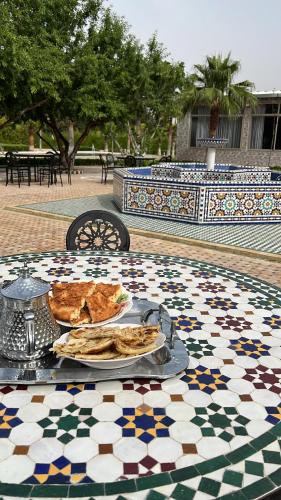 una mesa con un plato de comida encima de una mesa de mosaico en Les portes de l'atlas en Fez