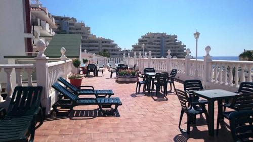a patio with chairs and tables on a balcony at Hotel Betania in Benalmádena