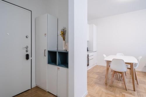 cocina blanca con mesa y sillas blancas en RELSTAY - CityLife - 2BR en Milán