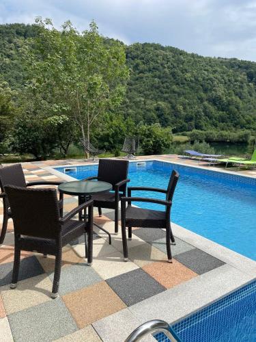 a patio with a table and chairs next to a swimming pool at Holiday Villa Abu Ibrahim in Bihać