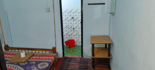 a small room with a bed and a table at The Blues in Alleppey