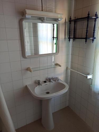 La salle de bains est pourvue d'un lavabo et d'un miroir. dans l'établissement Casa en Puerto de Bares, à Bares