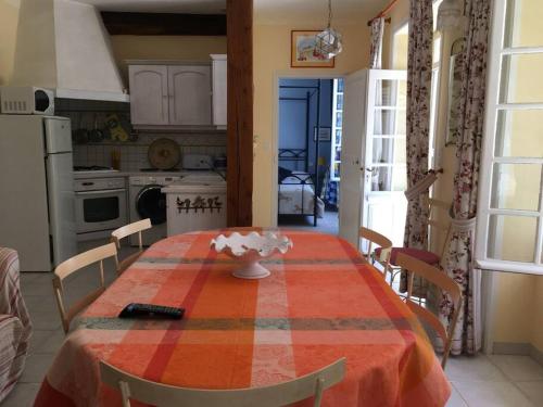 cocina con mesa y mantel rojo y naranja en La Maison des Roses en Mareuil-sur-Lay