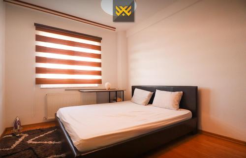a bedroom with a large bed with a window at Deluxe Apartment 1BR+ with Parking in Prishtinë