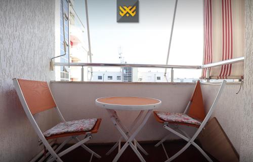 a table and two chairs in a room with a window at Deluxe Apartment 1BR+ with Parking in Prishtinë