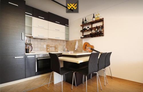 a kitchen with black cabinets and a table and chairs at Deluxe Apartment 1BR+ with Parking in Prishtinë