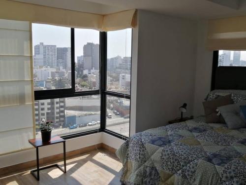 a bedroom with a bed and a view of a city at LOFT EN BARRANCO LIMITE CON MIRAFLORES - Monoambiente in Lima