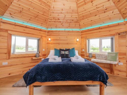 a bedroom with a bed in a wooden cabin at Dragonfly Retreat in Pentney