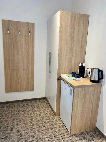 a kitchen with a counter and two wooden doors at GreenWood Vendégház in Siófok
