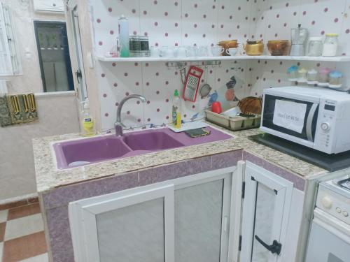 kuchnia z fioletowym zlewem i kuchenką mikrofalową w obiekcie residhome w Satif