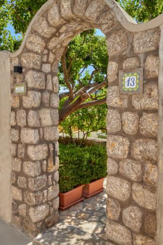 an archway in a stone wall with a sign on it at Villa Giardini Luxury Room in Capri