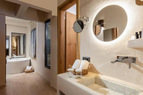 La salle de bains est pourvue d'une baignoire, d'un lavabo et d'un miroir. dans l'établissement Gran Via Alsancak, à Konak