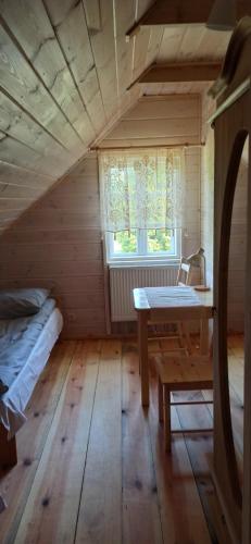 een kamer met een tafel, een bed en een raam bij Gościniec Pod Dębami I 