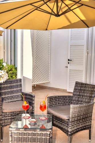 a patio with chairs and a table with a yellow umbrella at Villa Giardini Luxury Room in Capri
