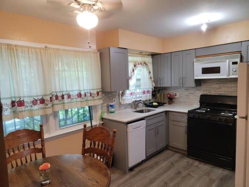 a kitchen with white cabinets and a table and a dining room at 1st floor Private Apt near Ferry to NYC and Park in Tompkinsville
