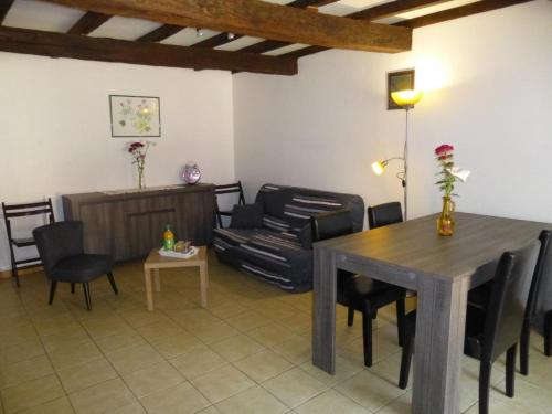 ein Wohnzimmer mit einem Holztisch und Stühlen in der Unterkunft Le moulin neuf - les lilas in Chalandray