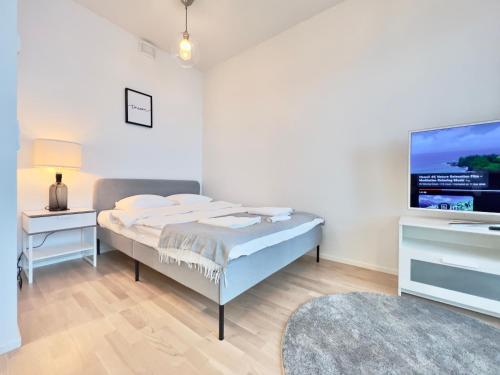 a bedroom with a bed and a flat screen tv at Stunning Central Apartment Helsinki in Helsinki