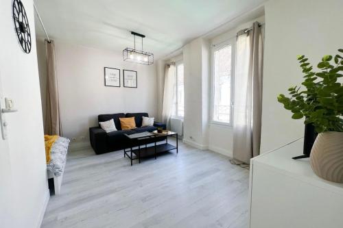 ein Wohnzimmer mit einem Sofa und einem Tisch in der Unterkunft Ô Confluent in Montereau-faut-Yonne