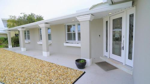 a white house with a front porch with a rug at Dolphin Cove in Cocoa Beach Fl in Cocoa Beach
