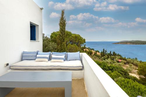 a bench on a balcony with a view of the ocean at Hidesign Athens Villa In Sounio in Sounio