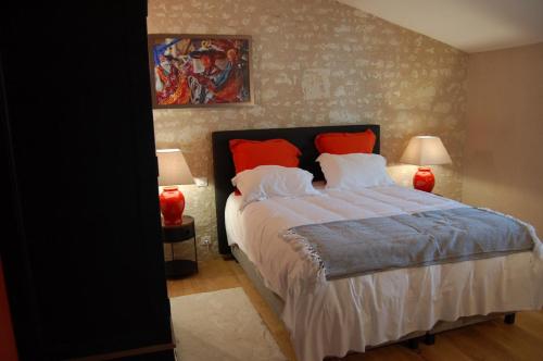 1 dormitorio con 1 cama grande con almohadas rojas en Domaine du haut vernay, en Bournand