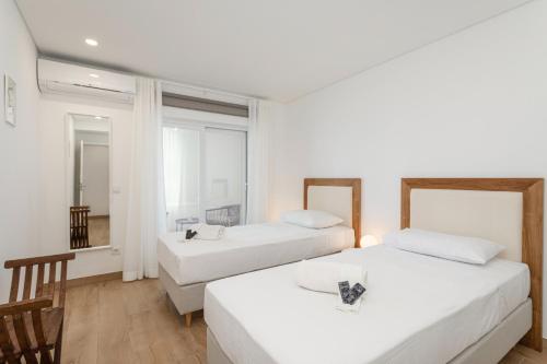 a hotel room with two beds and a window at Centralgarve - Premium Apartment in the Center of Vilamoura - Cota10 in Vilamoura