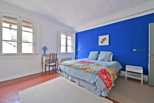 - une chambre bleue avec un lit et une chaise dans l'établissement Les Félibres, à Avignon
