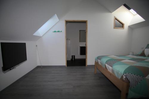 Schlafzimmer mit einem Bett und einem Flachbild-TV in der Unterkunft Gite montgolfiere in Châtellerault