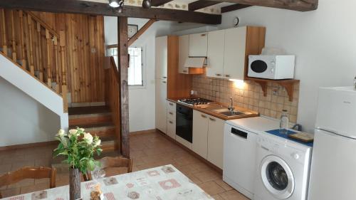 eine Küche mit einer Spüle und einem Herd Top-Backofen in der Unterkunft Le moulin neuf - l'aubepine in Chalandray