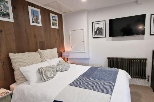 a bedroom with a large bed with a tv on the wall at The Old Barn Annexe, cosy stay near the city, beach, South Downs & Goodwood in Chichester