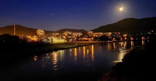 a view of a river at night with a city at U Bocmana s výhledem na zámek a Labe in Děčín
