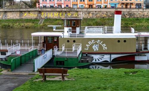 a boat is docked next to a bench at U Bocmana s výhledem na zámek a Labe in Děčín