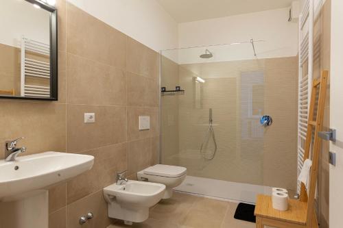 een badkamer met een wastafel, een toilet en een douche bij La Marmotta - Music Home in Belgirate