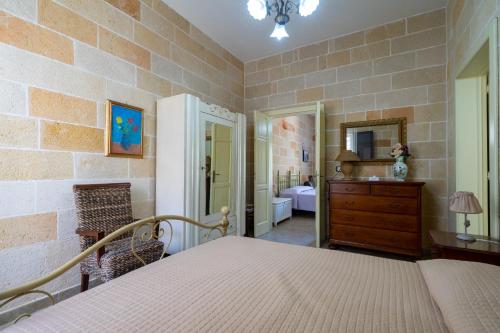 ein Schlafzimmer mit einem Bett und einer Kommode sowie ein Badezimmer in der Unterkunft Casa Maredoro by BarbarHouse in Nardò